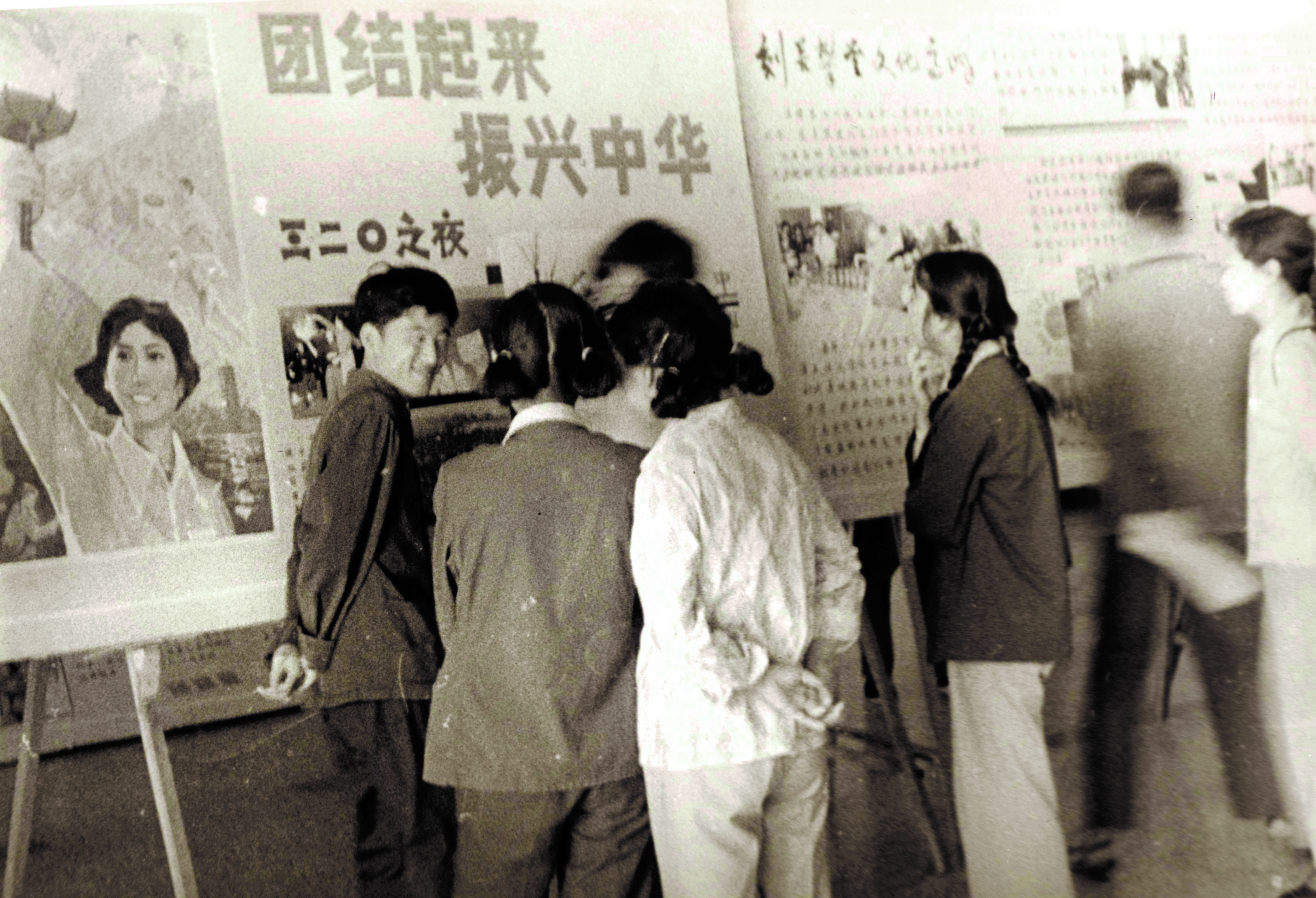 bb7d43a12e3947acac91b6e00db02137.jpg 1981年3月20日,中國男子排球隊戰(zhàn)勝南朝鮮隊,取得參加世界杯排球賽的資格,北大校園沸騰了,北大學生喊出了“團結起來,振興中華”的口號。圖為北大學生在海報欄前面熱烈議論.jpg